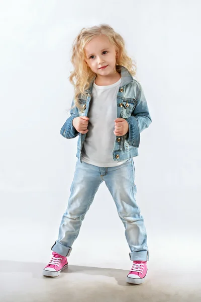 Маленькая модница позирует в джинсовом костюме — стоковое фото