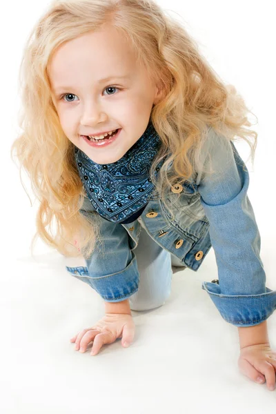 Vijf-jarig meisje in een denim pak doorzoekt op haar knieën vooruit — Stockfoto