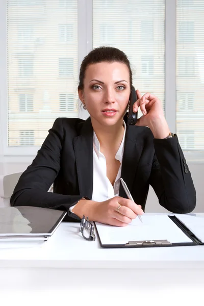 Zakenvrouw in een pak praten over een telefoon — Stockfoto