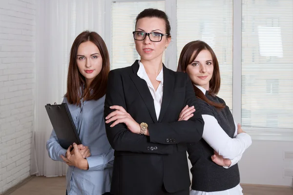 Las mujeres en ropa formal son de diferentes alturas con sus brazos c — Foto de Stock