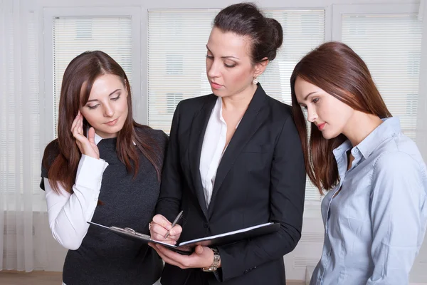 Tres chicas están estudiando la información en una carpeta — Foto de Stock