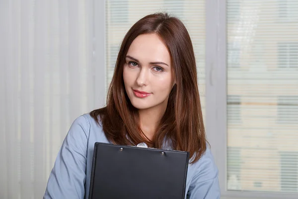 Woman in formal attire holding a folder — Stock Photo, Image