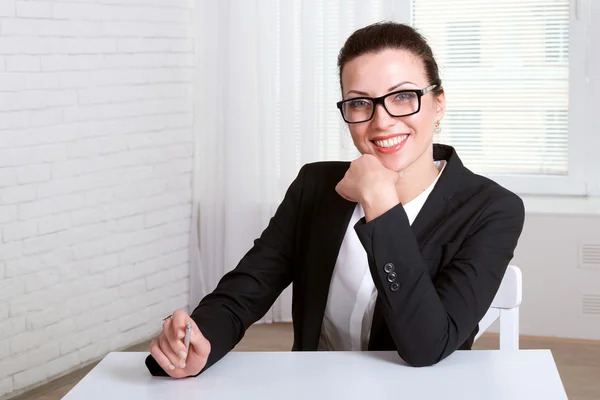 Head girl resting her hand on her chin and smiling — Stock Photo, Image