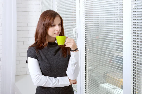 Ragazza beve caffè vicino alla finestra — Foto Stock