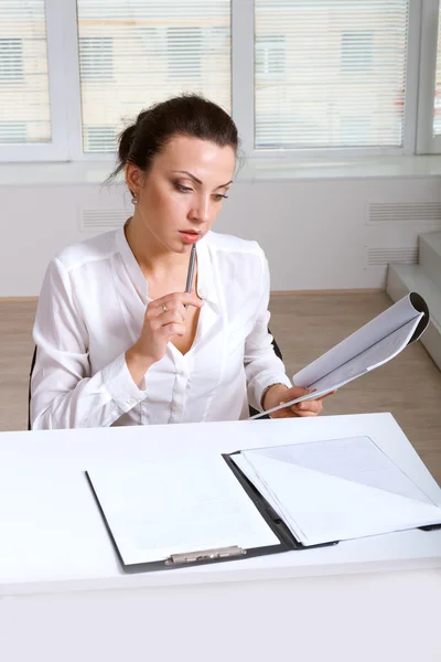 Girl studying documents sitting at the table — Stock Photo, Image