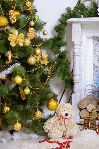 Christmas tree against a white fireplace — Stock Photo, Image