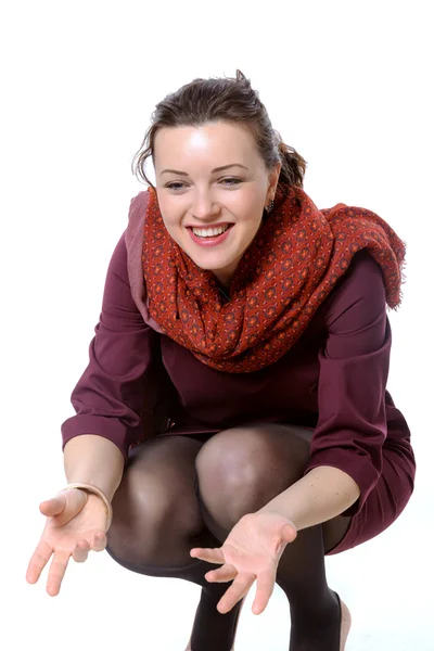 Девушка с шарфом на корточках и смеется над собой приглашает — стоковое фото