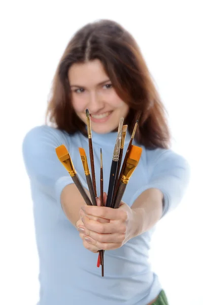 Menina artista segurando escovas na frente dela no comprimento do braço — Fotografia de Stock