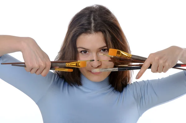 Painter holding brushes in front of her face — Stock Photo, Image