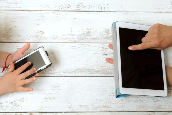 Mother and child are holding tablet and a phone — Stock Photo, Image