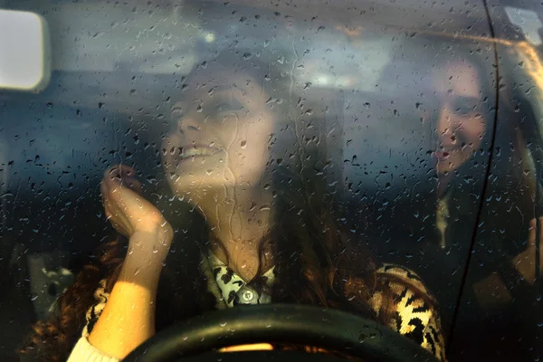 Two girls riding in the car in the rain
