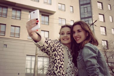 Kendini fotoğraflarını ve gülümseyen iki kız 