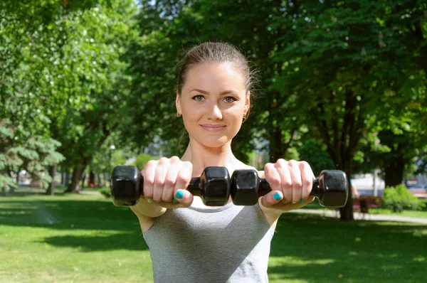 Sportowe dziewczyna robi ćwiczenia z hantlami łatwe — Zdjęcie stockowe