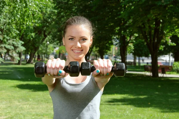 Chica deportiva haciendo ejercicio con mancuernas fáciles —  Fotos de Stock
