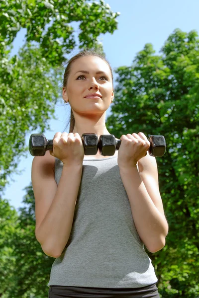 Sportsjente trener med lettvektige dumbjeller – stockfoto