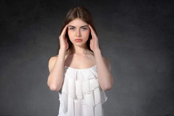 Girl shows that she had a headache against a dark background — Stock Photo, Image