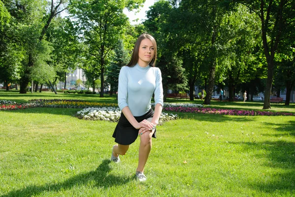 Chica haciendo estiramiento pierna al aire libre en el parque — Foto de Stock
