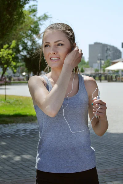 Mujer del deporte escuchando música con auriculares —  Fotos de Stock