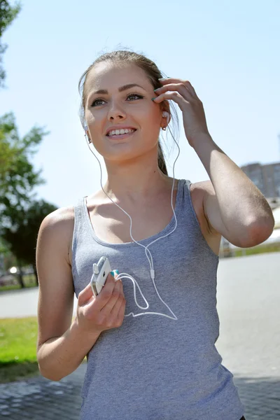 Mujer del deporte se detuvo y escucha música —  Fotos de Stock