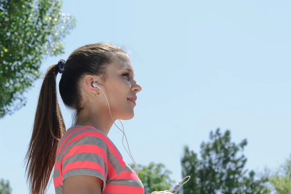 Esporte mulher ouvindo música no telefone — Fotografia de Stock