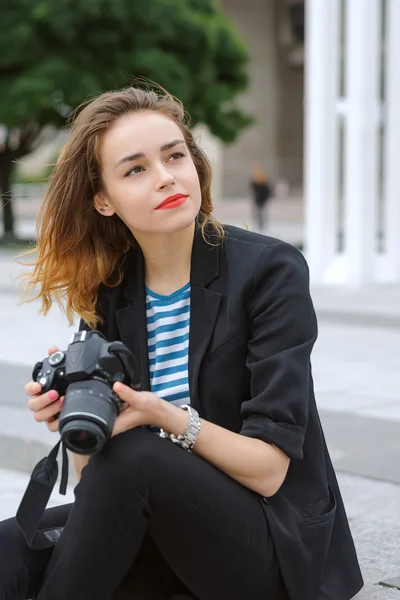 Woman photographer sits on the steps — Stock Photo, Image