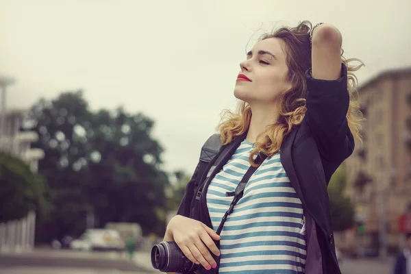 Woman with a camera enjoys being in the city — Stock Photo, Image