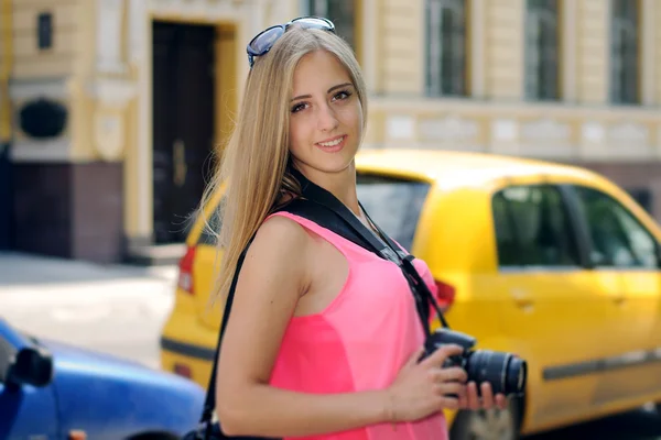 Menina turista anda pela cidade com uma câmera — Fotografia de Stock