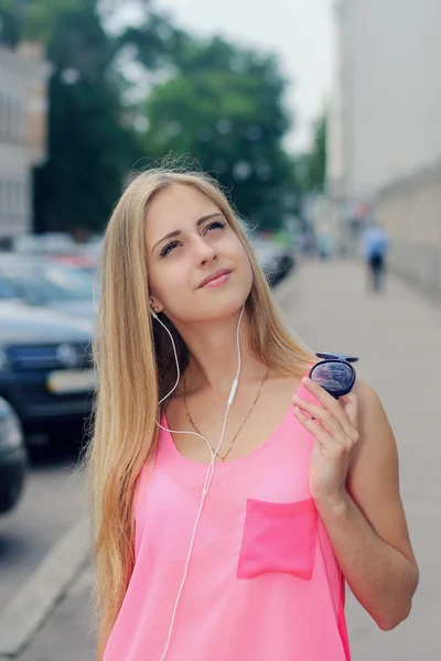Mädchen geht die Straße entlang und hört Musik — Stockfoto
