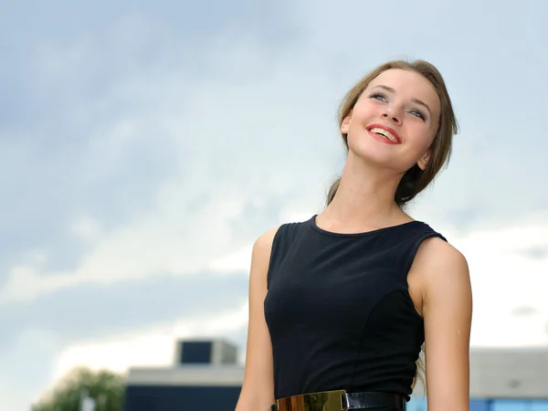 Zakenvrouw glimlachend tegen een blauwe achtergrond — Stockfoto