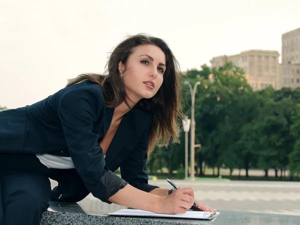Femme d'affaires prend des notes dans ses documents d'affaires — Photo