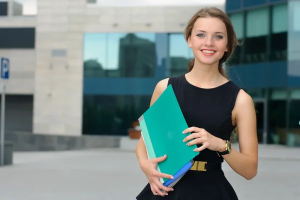 Woman walking on business district with folders — Stock Photo, Image