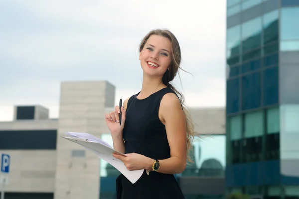Flicka med en mapp för papper i hennes händer skrattar glatt — Stockfoto