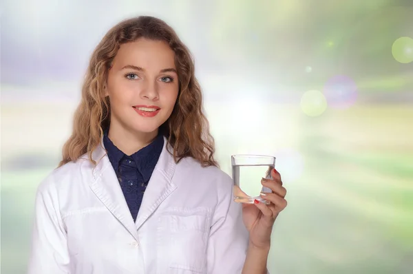 Kvinna läkare håller ett glas rent vatten och ler — Stockfoto