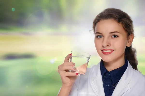 Kvinna läkare leende och dricka vatten från ett glas cup — Stockfoto