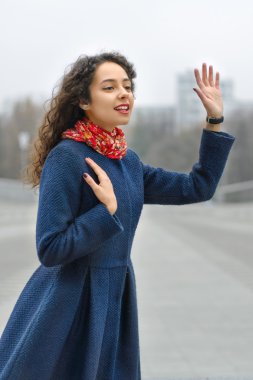 Mavi paltolu kızın elini bir şehir sokak dalgalar.