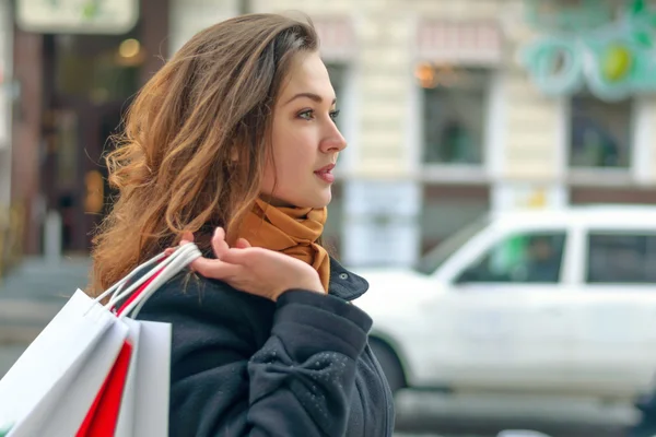 Meisje wandelingen langs een straat met boodschappentassen stad — Stockfoto