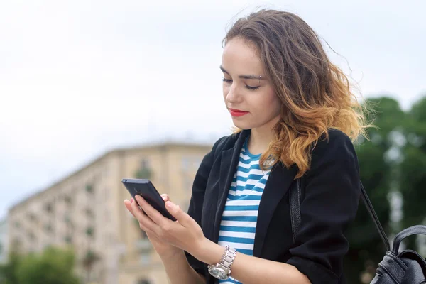 Mujer se comunica en un teléfono móvil —  Fotos de Stock