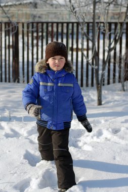 Kar üzerinden çalışan mavi ceketli çocuk