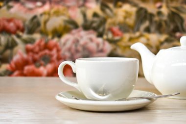 Restoranın arka planında beyaz fincan ve çaydanlık var. Masada bir çift çay. Metin için boşluk