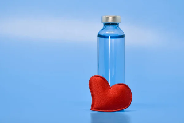 Şeffaf Tıbbi Ampuller Açık Mavi Arka Planda Kırmızı Bir Kalp — Stok fotoğraf