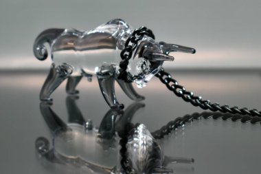 Boynunda siyah metal bir zincir olan bir boğanın cam figürü aynalı arka planda yansımasına bakıyor. Zincire vurulmuş boğa. Seçici odaklanma. 2021 'in sembolü.