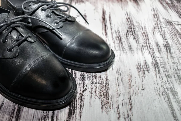 黑色皮鞋的纹理木制背景 一双时髦的女靴在层压板地板上 顶视图 皮革鞋类护理 定制裁剪 鞋类修补 案文的篇幅 — 图库照片