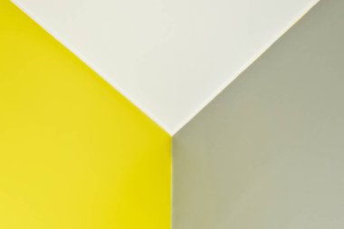 Soyut grafik arkaplan sarı ve gri renklerde. Duvarda düz çizgiler, üç kenarlı bir köşe. Üç boyutlu bir doku. Yılın rengi 13-0647 ve Ultimate Gray 17-5104 'ü aydınlatıyor. Metin için boşluk