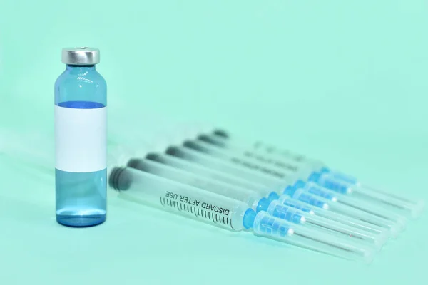 ターコイズ の背景に注射用のCovid 19ワクチンと注射用注射器を備えた医療用アンプル ボトルの白いラベル テキストの場所 感染症の予防接種です Covid 19ワクチンバイアル — ストック写真