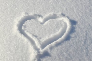 Kalp karlı açıklıkta çizilir. Sevgililer Günü 'nde dekorasyon için arka plan. Soğuk kalp, aşkım. Kışın beyaz kar, romantizm. Karda aşk sembolü. Metin için boşluk