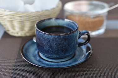 Sabahları kafede bir fincan sade kahve. İş yemeğinde sade kahve ve bir sepet kızarmış ekmek ve kamış şekeri. Günaydın enerji, motivasyon konsepti. seçici odak