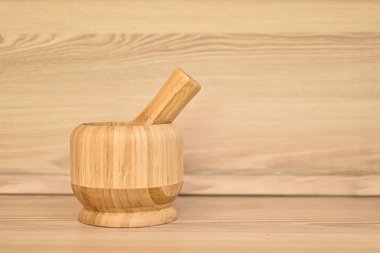 Baharatlar için bambu harcı. Mutfak içi bej, mutfak masasında ahşap harç ve tokmak. Çevre dostu materyaller. Metin için boş boşluk.