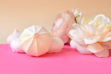 Kutlama kartpostalı. Küçük kremalı pasta ve pembe arka planda çiçekler. Mesaj için yer var. Tatlı ve çiçekli pastel renkli arka plan. Seçici odak