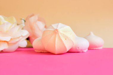 Kutlama kartpostalı. Küçük kremalı pasta ve pembe arka planda çiçekler. Mesaj için yer var. Tatlı ve çiçekli pastel renkli arka plan. Seçici odak