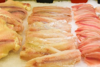 Tezgahta taze balık var. Buzda balık filetosu. Soğutulmuş deniz ürünleri, çiğ morina balığı ve balık pazarında buzlu levrek fileto. Sağlıklı yiyecekler, protein, vitamin, mineral ve omega-3 kaynakları